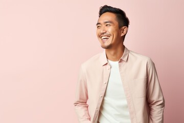 Wall Mural - Portrait of a happy young asian man isolated on pink background