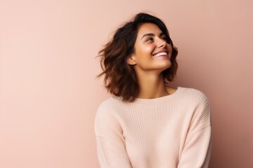 Wall Mural - Portrait of a beautiful young woman smiling on a pink background.