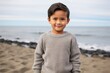 © Leon Waltz - Lifestyle portrait of a Indonesian child male in a beach background wearing a cozy sweater