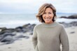 © Leon Waltz - Lifestyle portrait of a Russian woman in her 40s in a beach background wearing a cozy sweater