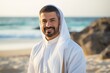 © Leon Waltz - Portrait of smiling arabic man standing on beach during sunny day