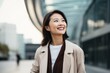 © Leon Waltz - Portrait of a smiling businesswoman standing in the street and looking away