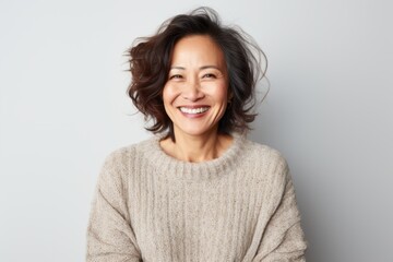 Wall Mural - Portrait of a Chinese woman in her 40s in a white background wearing a cozy sweater