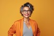 © Leon Waltz - Cheerful middle-aged woman in orange jacket and eyeglasses