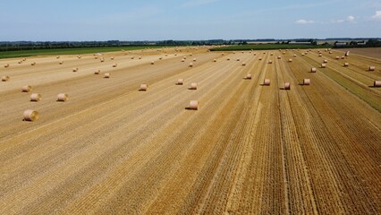 Poster - Idyllic rural scene featuring large bales of hay sitting in a field on a sunny day in France