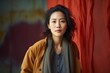 © Hanne Bauer - Medium shot portrait of a Chinese woman in her 30s in an abstract background wearing a chic cardigan