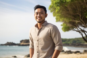 Portrait of a young asian man smiling at the beach.