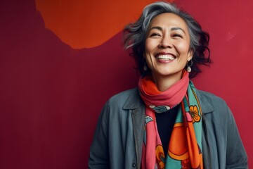 Wall Mural - Portrait of a Indonesian woman in her 50s in an abstract background wearing a chic cardigan