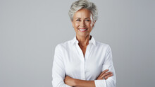 Successful Businesswoman With Crossed Arms Stands On A Gray Background.