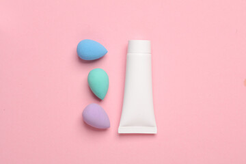 Wall Mural - Make-up puffs for foundation and cream tube on a pink background. Beauty concept