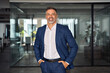 © Stock 4 You - Handsome hispanic senior business man in confident pose smiling at camera. Indian or latin confident mature good looking middle age leader male businessman on blur office background with copy space.