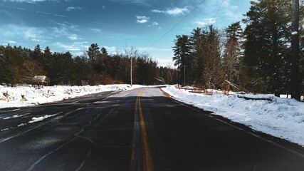 Sticker - Scenic view of an empty asphalt road in snow on sidewalks near a forest in winter