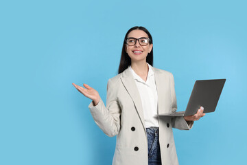 Poster - Happy woman with laptop on light blue background