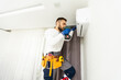 © Angelov - Male technician cleaning air conditioner indoors