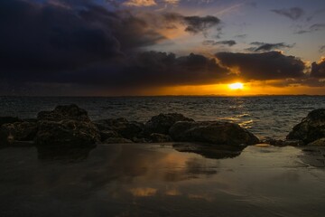 Poster - Scenic view of a rocky beach at a cloudy sunset