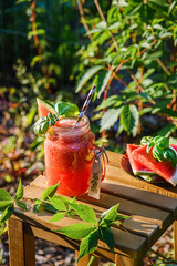 Wall Mural - watermelon smoothie on a wooden table outside