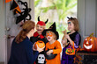 © famveldman - Kids trick or treat. Halloween. Child at door.