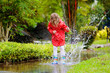 © famveldman - Child playing in puddle. Kids jump in autumn rain
