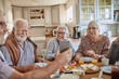 © Marko Geber - Senior people having breakfast and using a smart phone at home in a nordic styled kitchen