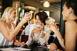 © Marko Geber - Group of businesswoman having wine in a cafe bar after work