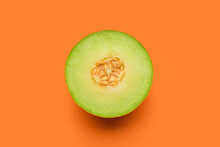 Half Of Tasty Ripe Melon On Orange Background