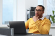 © New Africa - Young man working on laptop at table in office