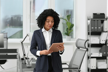 Poster - Young businesswoman using tablet in modern office