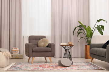 Poster - Stylish gray armchair and small table in living room. Interior design