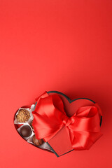 Canvas Print - Heart shaped box with delicious chocolate candies on red table, top view. Space for text