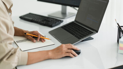 Wall Mural - developer programmer use mouse and checking code on laptop while programming to developing website