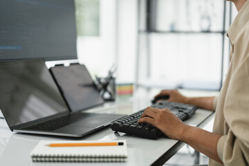 Wall Mural - developer programmer checking code on multiple monitor while programming to developing web and apps