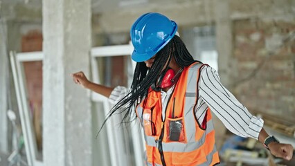 Wall Mural - African american woman builder smiling confident dancing at construction site