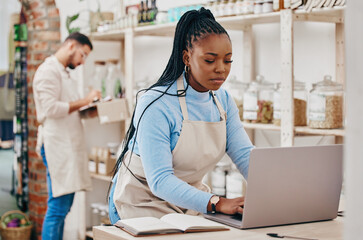 Grocery store, small business and black woman at counter with laptop for stock inventory, planning and sales report. Computer, internet and manager at sustainable supermarket with eco friendly care.