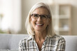 Cheerful beautiful blonde mature woman in trendy eyeglasses and casual shirt looking at camera, smiling, showing white teeth. Happy senior freelance business lady head shot video call portrait