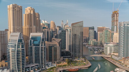  Dubai Marina with several boat and yachts parked in harbor and skyscrapers around canal aerial timelapse.