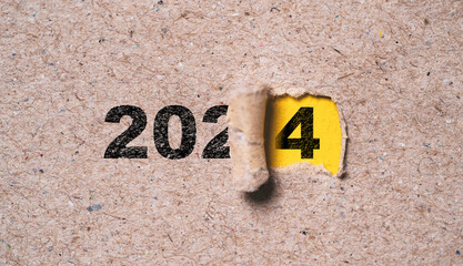 Wall Mural - number of 2024 inside of yellow hole of tear paper for change new year from 2023 to 2024 , merry chr