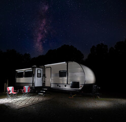 Wall Mural - bright milky way and stars over a travel trailer