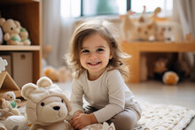 Full-body Shot Of A Happy 3-year-old Girl Playing On The Carpet In The Living Room With Toys Around. She Is Wearing A Light Beige Home Outfit