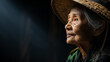 © Keitma - Side portrait of a old rice working woman with hat isolated on black background with copy space