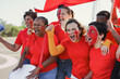 © Sabrina - Multi generational people having fun screaming outside of football stadium - Group of red football supporters