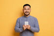 © Prostock-studio - Portrait Of Handsome Smiling Young Asian Man With Smartphone In Hands