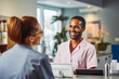 © VisualProduction - A smiling clinic secretary welcomes a client at the counter.