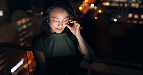 Canvas Print - Glasses, tablet and Asian woman in night office, working late on project deadline or research. Tech, overtime and female employee with touchscreen reading email, report or proposal in dark workplace.