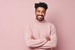 © Leon Waltz - Portrait of a happy young african american man with crossed arms against pink background