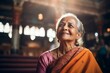 © Leon Waltz - Medium shot portrait of an Indian woman in her 60s wearing traditional sari in a hindu temple