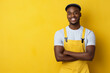 © amila - Smiling young handsome African electrician standing over yellow background