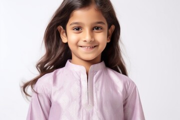 Wall Mural - Lifestyle portrait of an Indian child female wearing kurta pajama against a white background