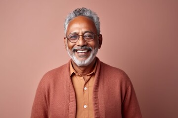 Wall Mural - Medium shot portrait of an Indian man in his 70s in a minimalist background