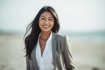 Wall Mural - Lifestyle portrait of an Indian woman in her 30s wearing a sleek suit in a beach 