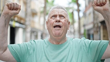 Sticker - Middle age grey-haired man smiling confident looking to the sky with winner expression at street